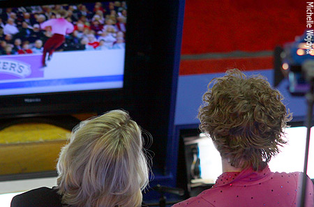 Adam Rippon and Karen Preston watch a replay of Adam's popped triple Axel